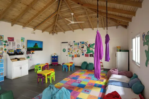A colorful kids club room with play tables and hanging fabric at Viva Tangerine.