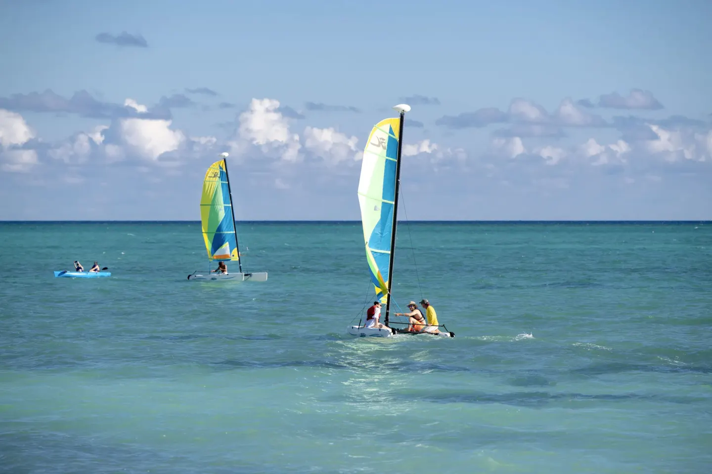 Small sailboats and a kayak on turquoise ocean water at Viva Tangerine.
