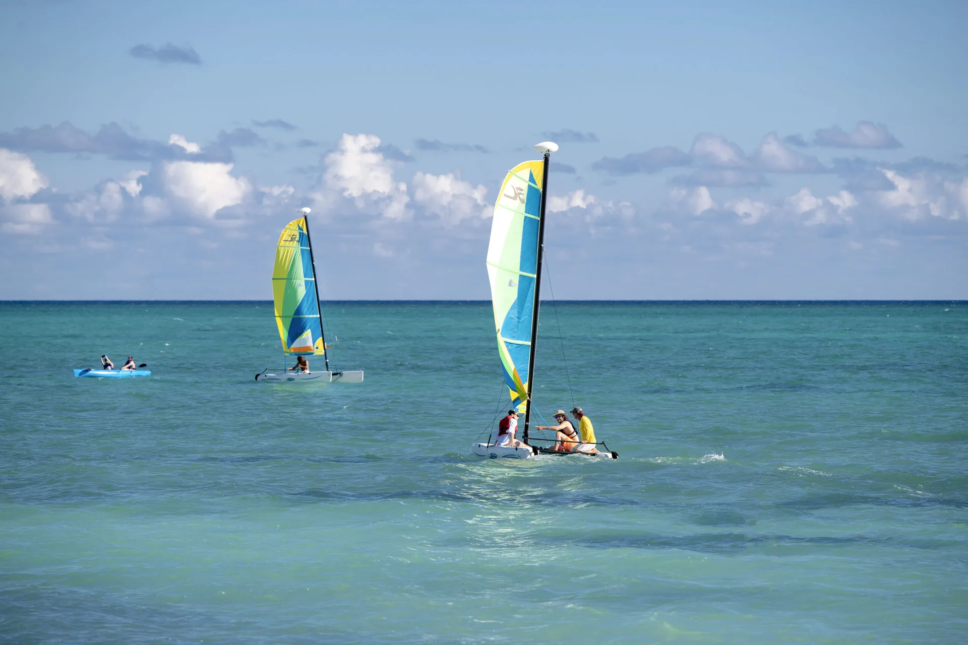 Small sailboats and a kayak on turquoise ocean water at Viva Tangerine.