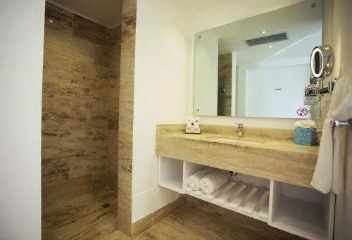 Accessible bathroom vanity and open shower area in a non-smoking room at Viva Tangerine.