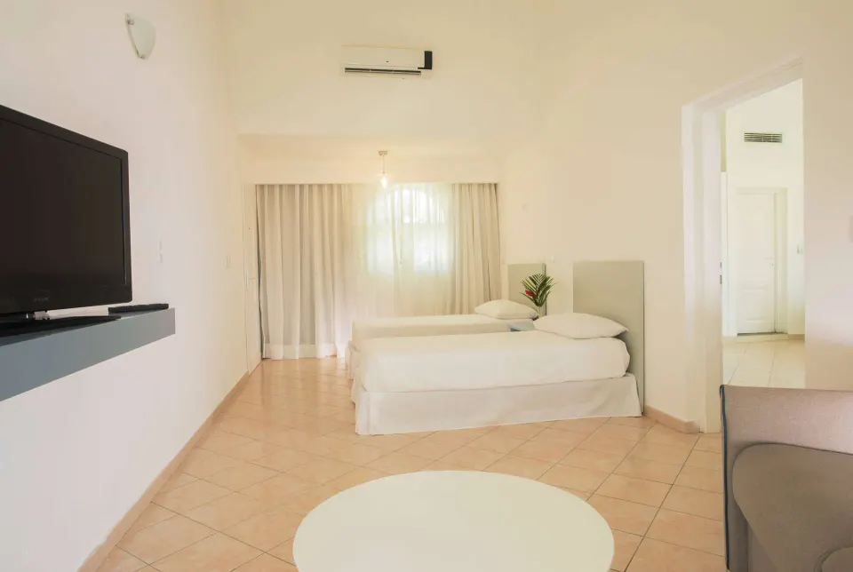 All Together Room with twin beds, TV, and seating area at Viva Tangerine.