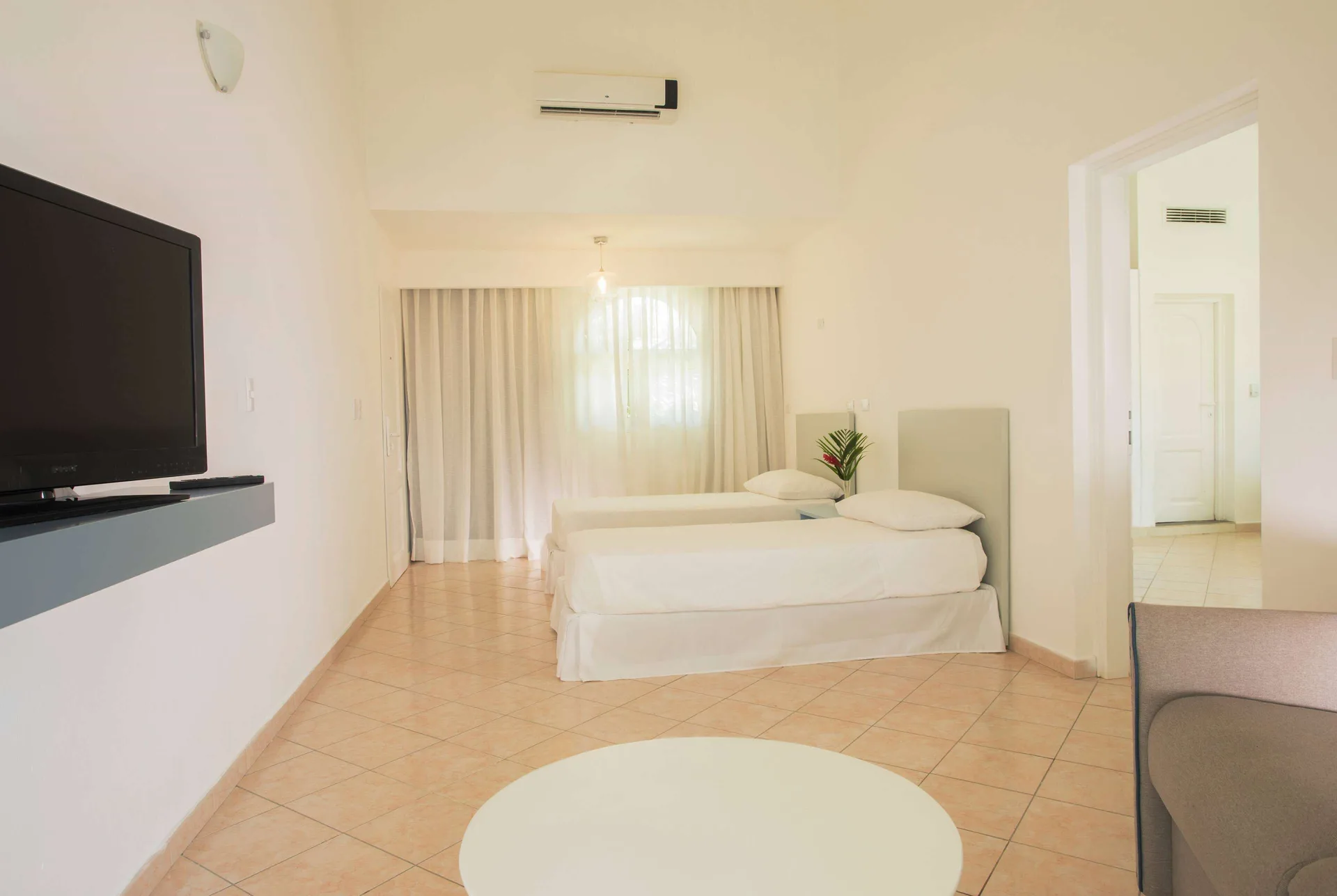 All Together Room with twin beds, TV, and seating area at Viva Tangerine.