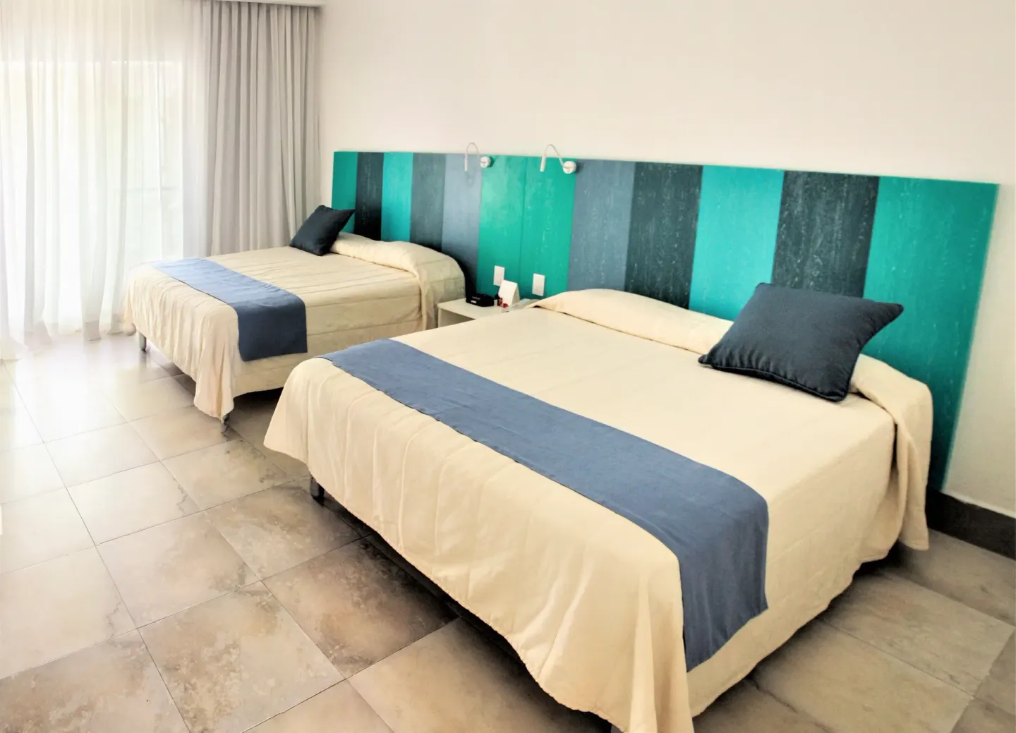 Superior Garden View Room with two beds and teal headboard at Viva Tangerine.