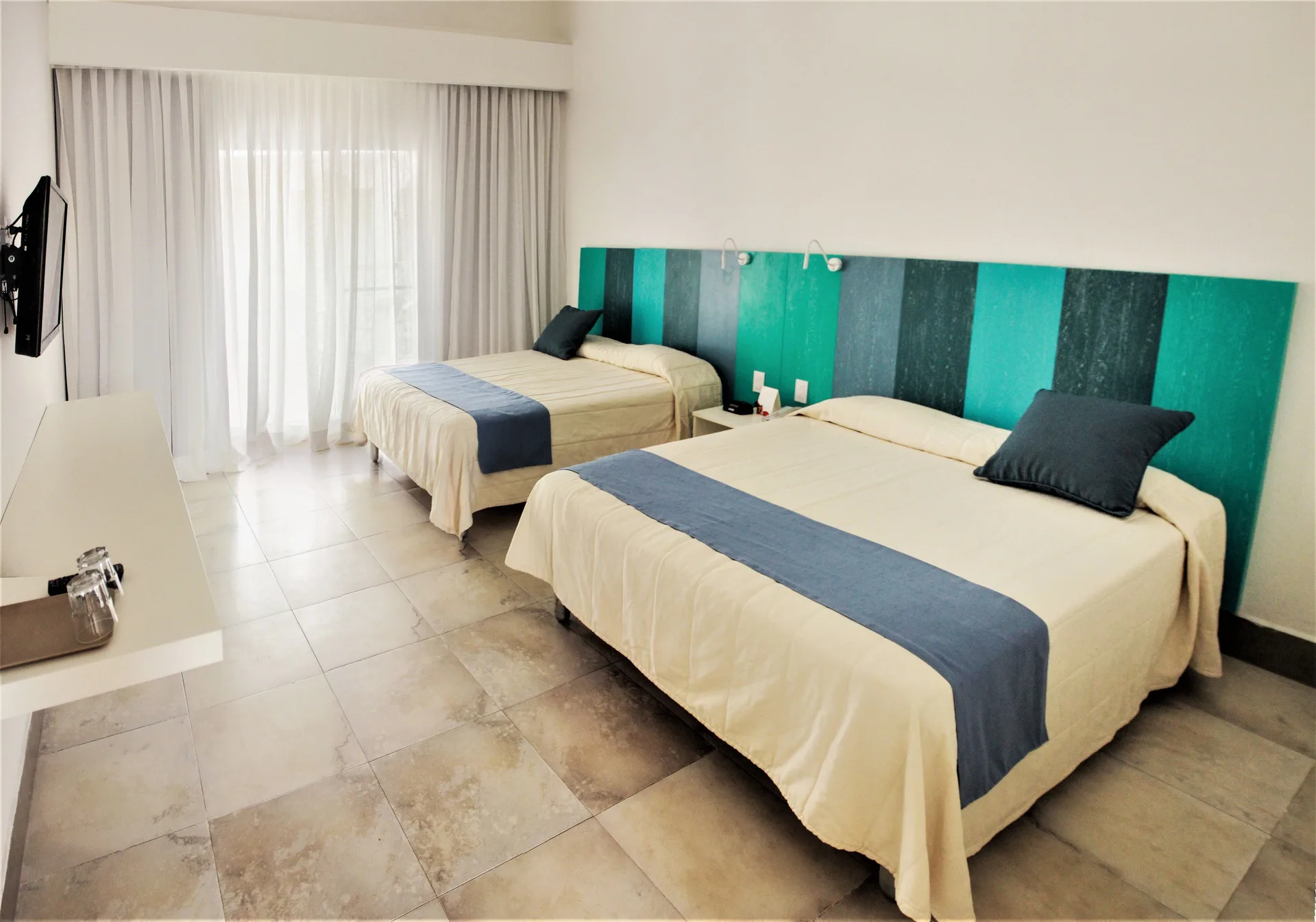 Superior Garden View Room with two beds, TV, and shelf at Viva Tangerine.