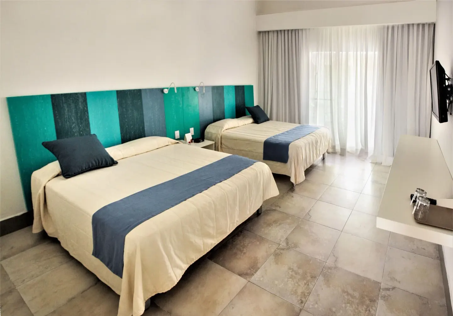 Superior Garden View Room with two beds and striped headboard at Viva Tangerine.