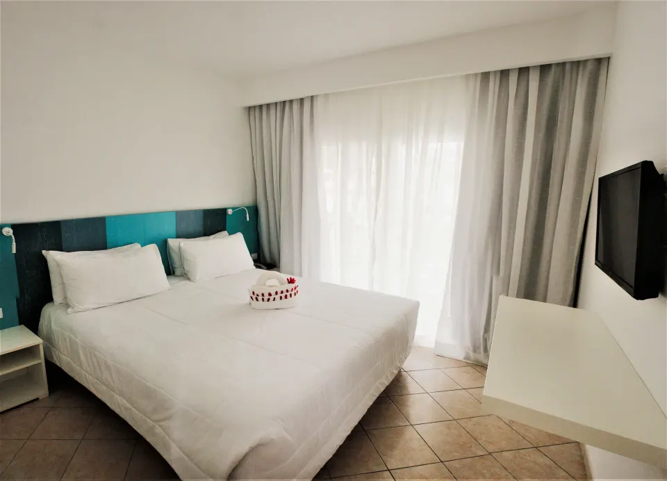 Superior Garden View Room with white bed and floating desk at Viva Tangerine.