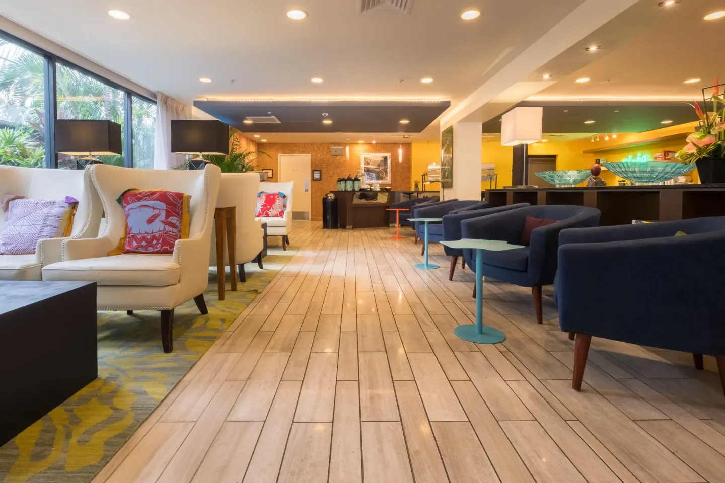 Long lobby view with lounge chairs and tile floor at Vive Hotel Waikiki.