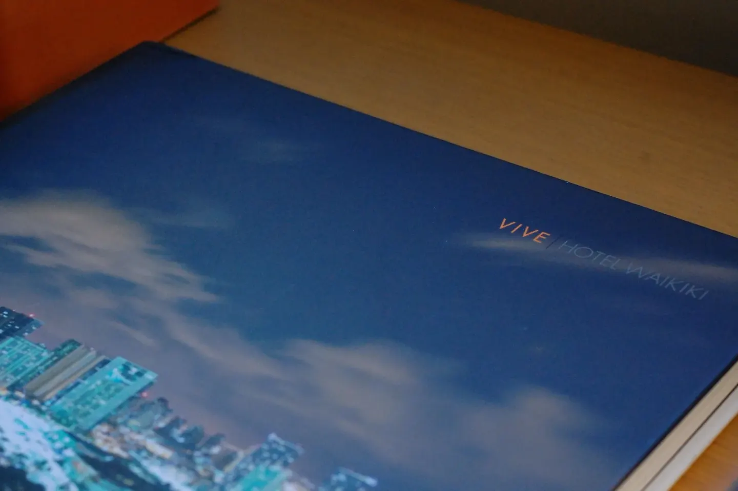 Close-up of a Vive Hotel Waikiki printed booklet on a tabletop.