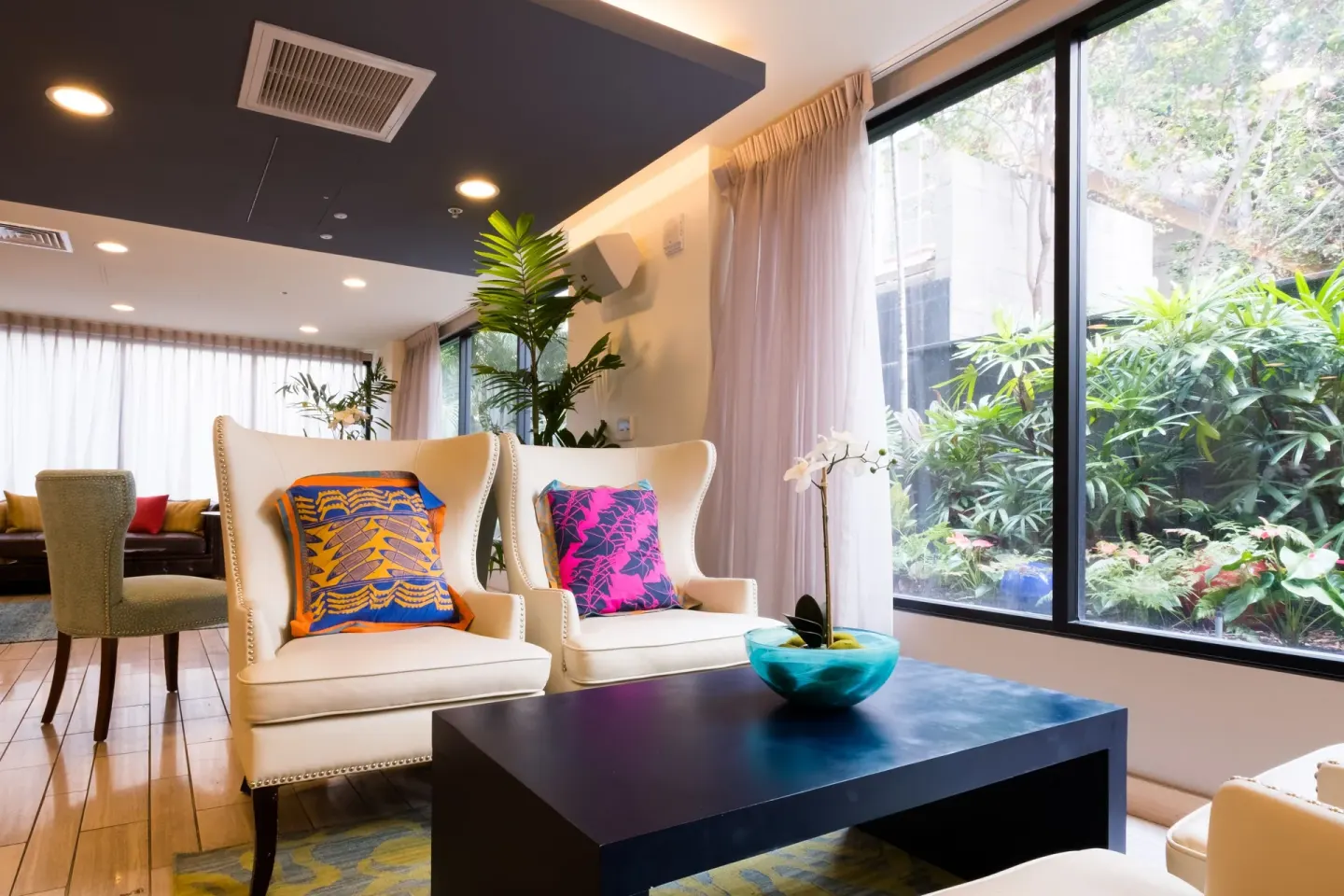 Window-side lobby chairs and coffee table at Vive Hotel Waikiki.
