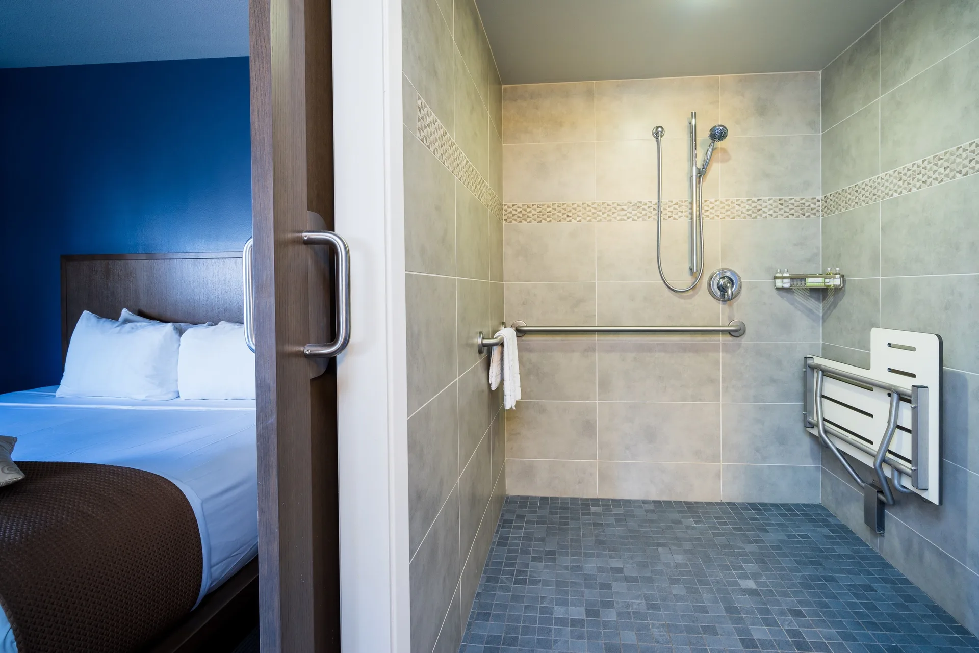 Accessible shower beside the bed in a Lifestyle Jr. Suite at Vive Hotel Waikiki.