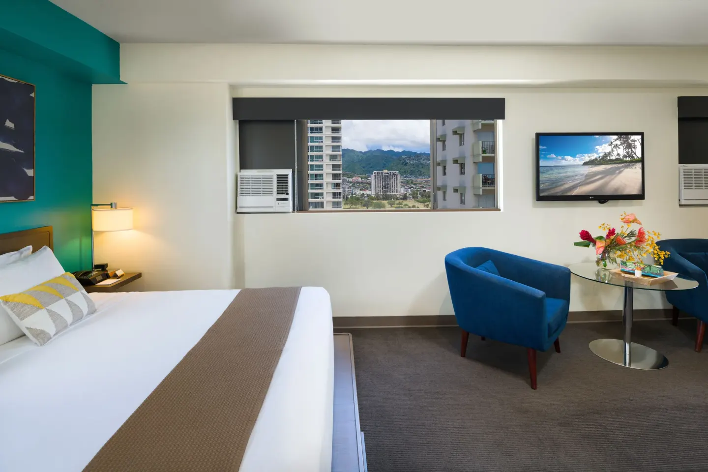 Lifestyle Jr. Suite bed and seating area with mountain views at Vive Hotel Waikiki.