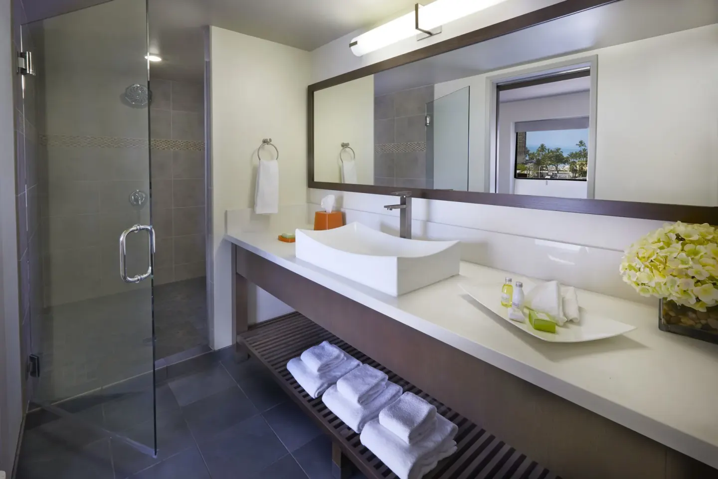 Bathroom vanity and glass shower in a Lifestyle Jr. Suite at Vive Hotel Waikiki.