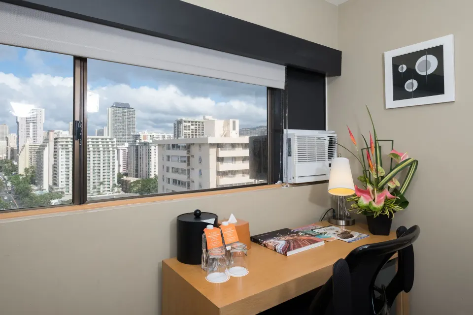 Desk and city-facing window in a Standard Room at Vive Hotel Waikiki.