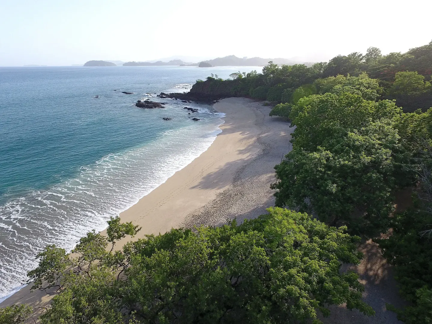 Aerial coastline with beach, surf, and forest at W Costa Rica - Reserva Conchal.