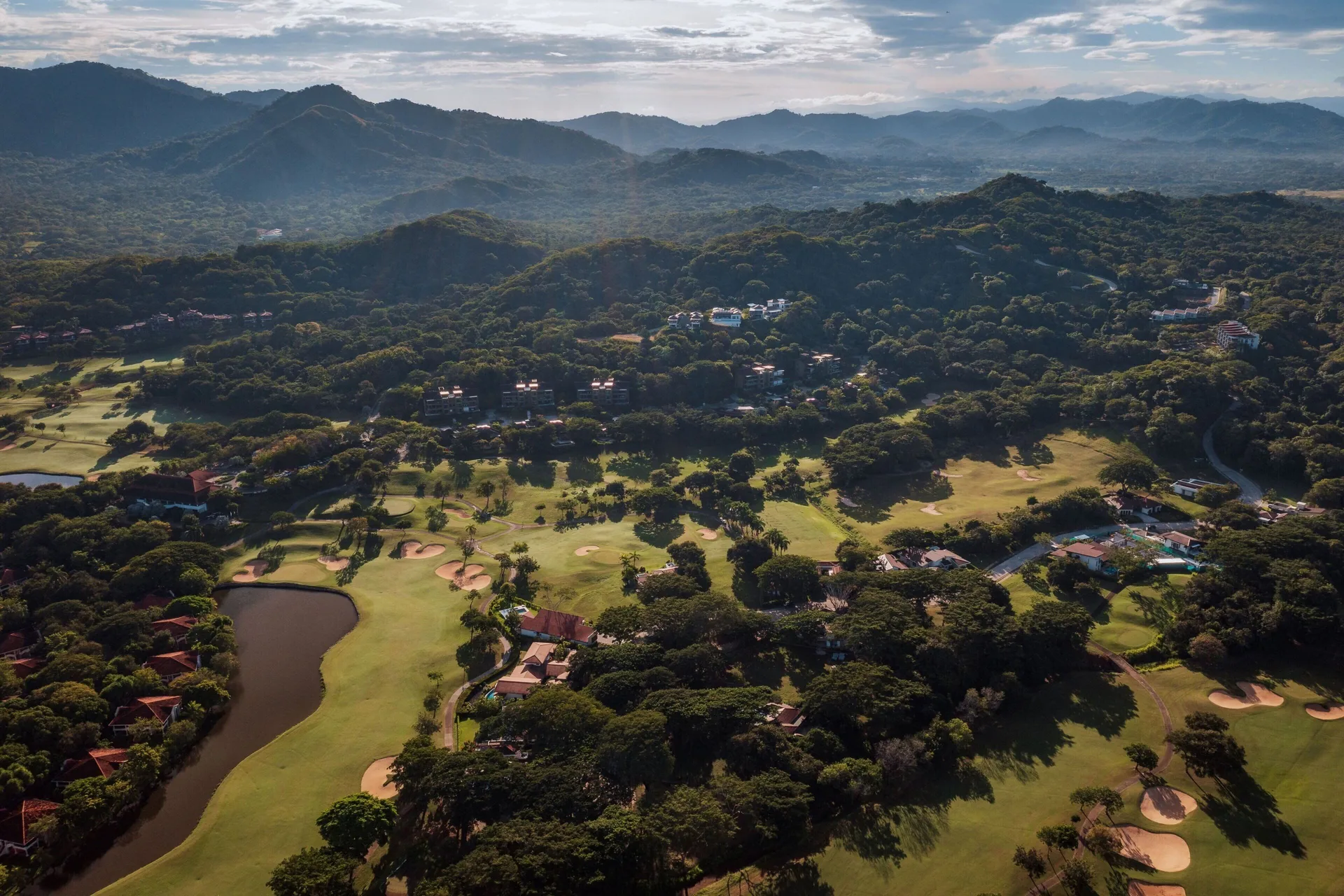 Aerial view of the golf course, forest, and mountains at W Costa Rica - Reserva Conchal.