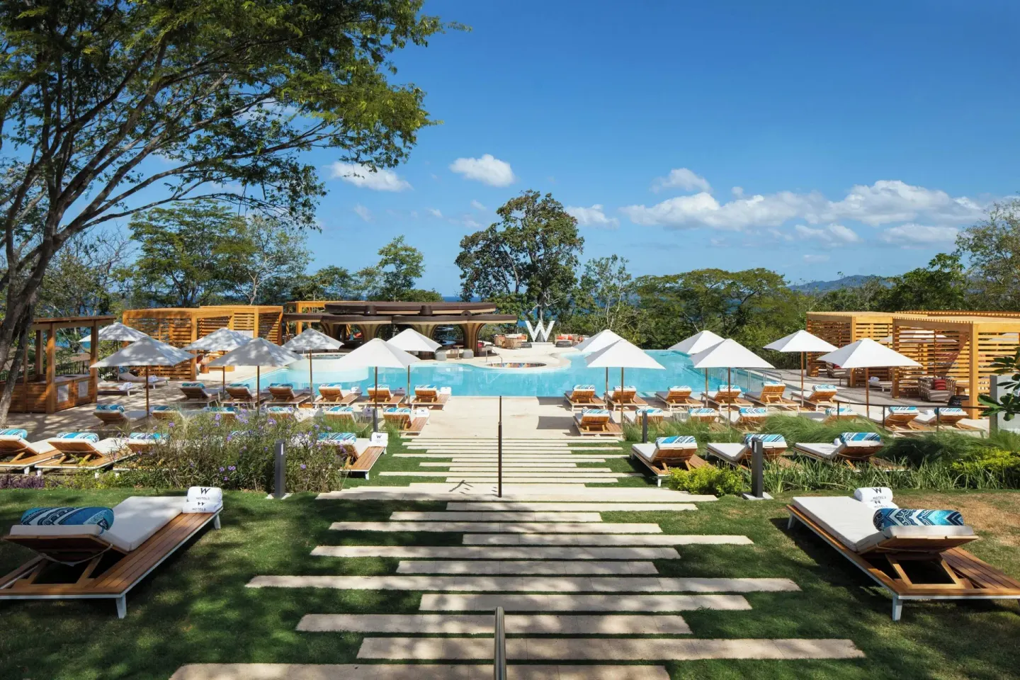 Pool deck with loungers, umbrellas, and cabanas at W Costa Rica - Reserva Conchal.
