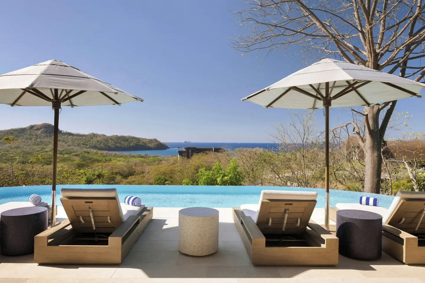 Pool deck with loungers, umbrellas and ocean view at W Costa Rica - Reserva Conchal.