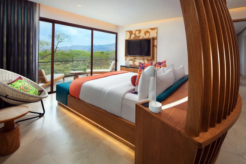 Deluxe Suite bedroom with king bed and balcony view at W Costa Rica - Reserva Conchal.
