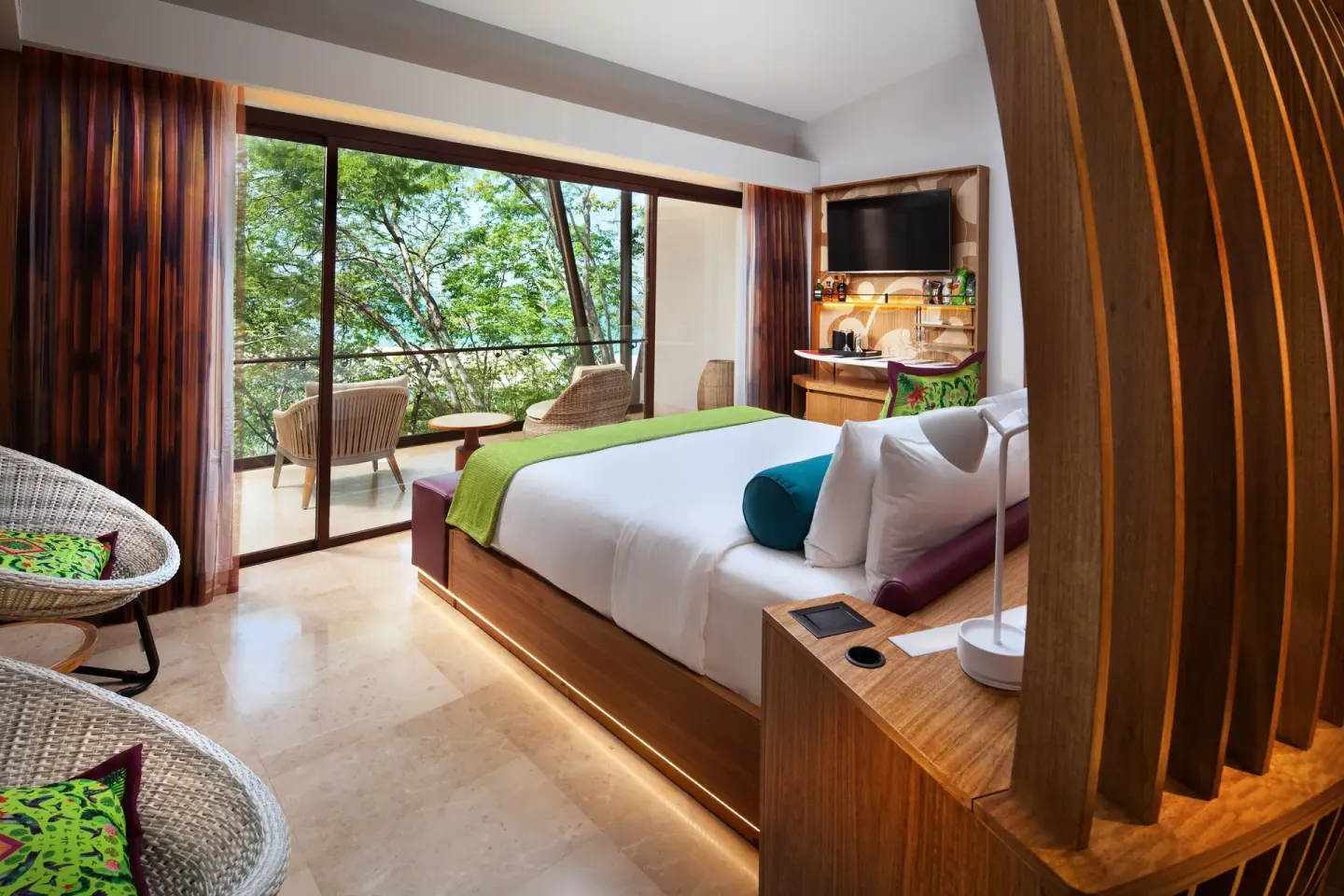 Superior Room with king bed, balcony seating, and trees at W Costa Rica - Reserva Conchal.