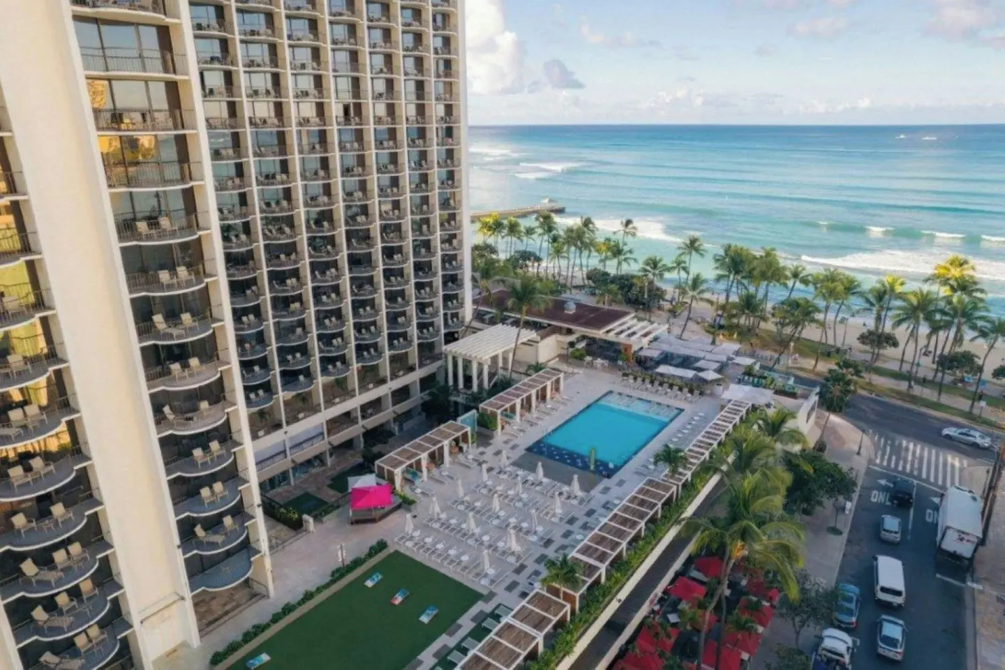 Aerial view of the pool deck, tower and Waikiki shoreline at Waikiki Beach Marriott Resort & Spa.