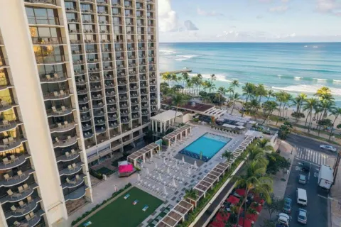 Aerial view of the pool deck, tower and Waikiki shoreline at Waikiki Beach Marriott Resort & Spa.