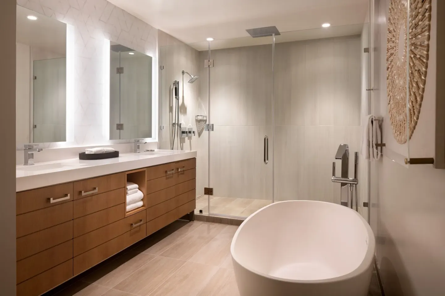 Bathroom with freestanding tub, long vanity, and glass shower at Waikiki Beach Marriott Resort & Spa.