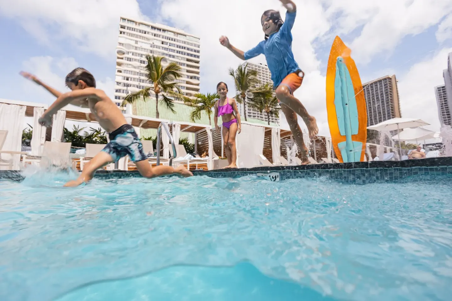 Children jumping into the resort pool at Waikiki Beach Marriott Resort & Spa.