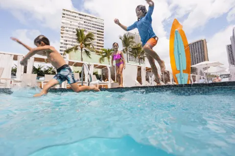Children jumping into the resort pool at Waikiki Beach Marriott Resort & Spa.