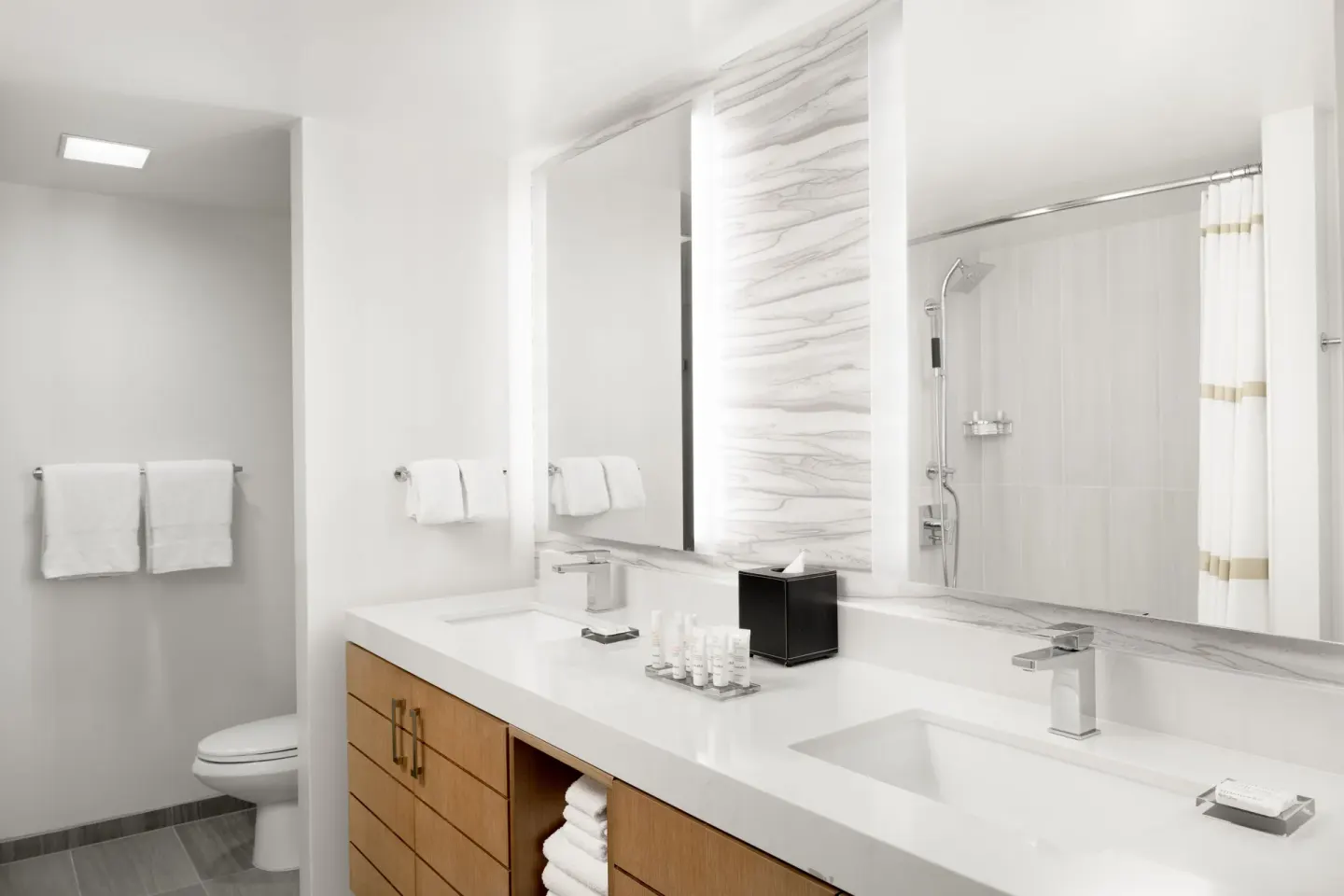 A double-vanity bathroom with shower and toilet at Waikiki Beach Marriott Resort & Spa.