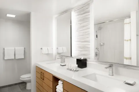 A double-vanity bathroom with shower and toilet at Waikiki Beach Marriott Resort & Spa.