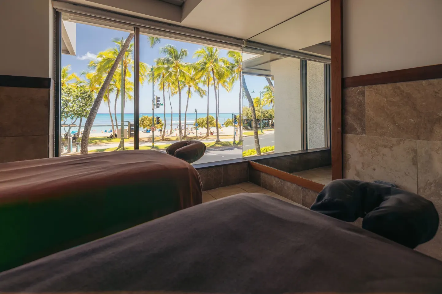Spa treatment beds overlook palms and the beach at Waikiki Beach Marriott Resort & Spa.