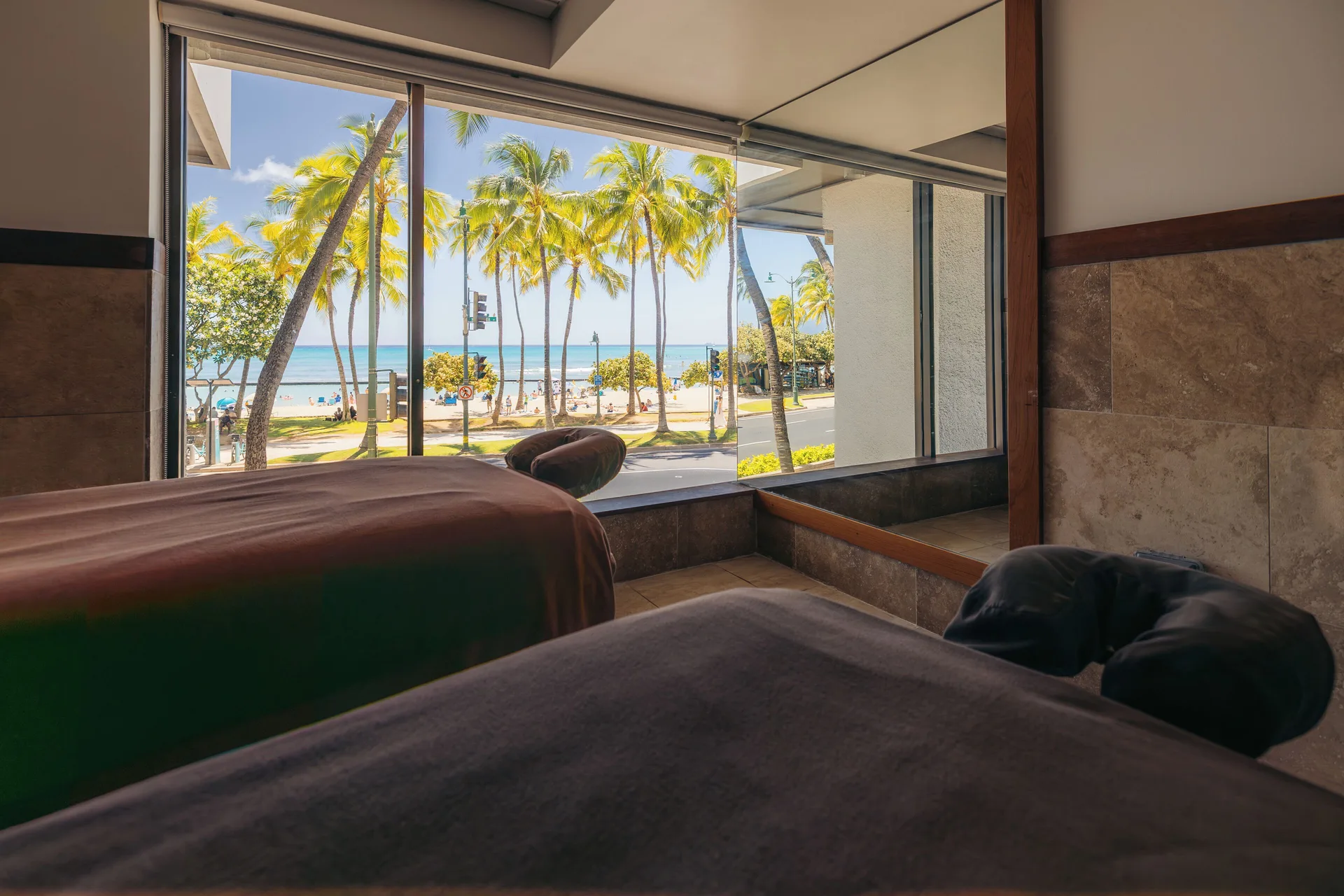Spa treatment beds overlook palms and the beach at Waikiki Beach Marriott Resort & Spa.