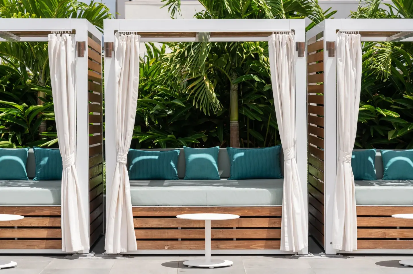 Curtained outdoor cabanas with blue cushions at Waikiki Beach Marriott Resort & Spa.