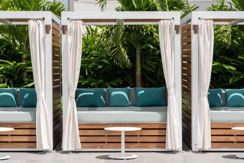 Curtained outdoor cabanas with blue cushions at Waikiki Beach Marriott Resort & Spa.