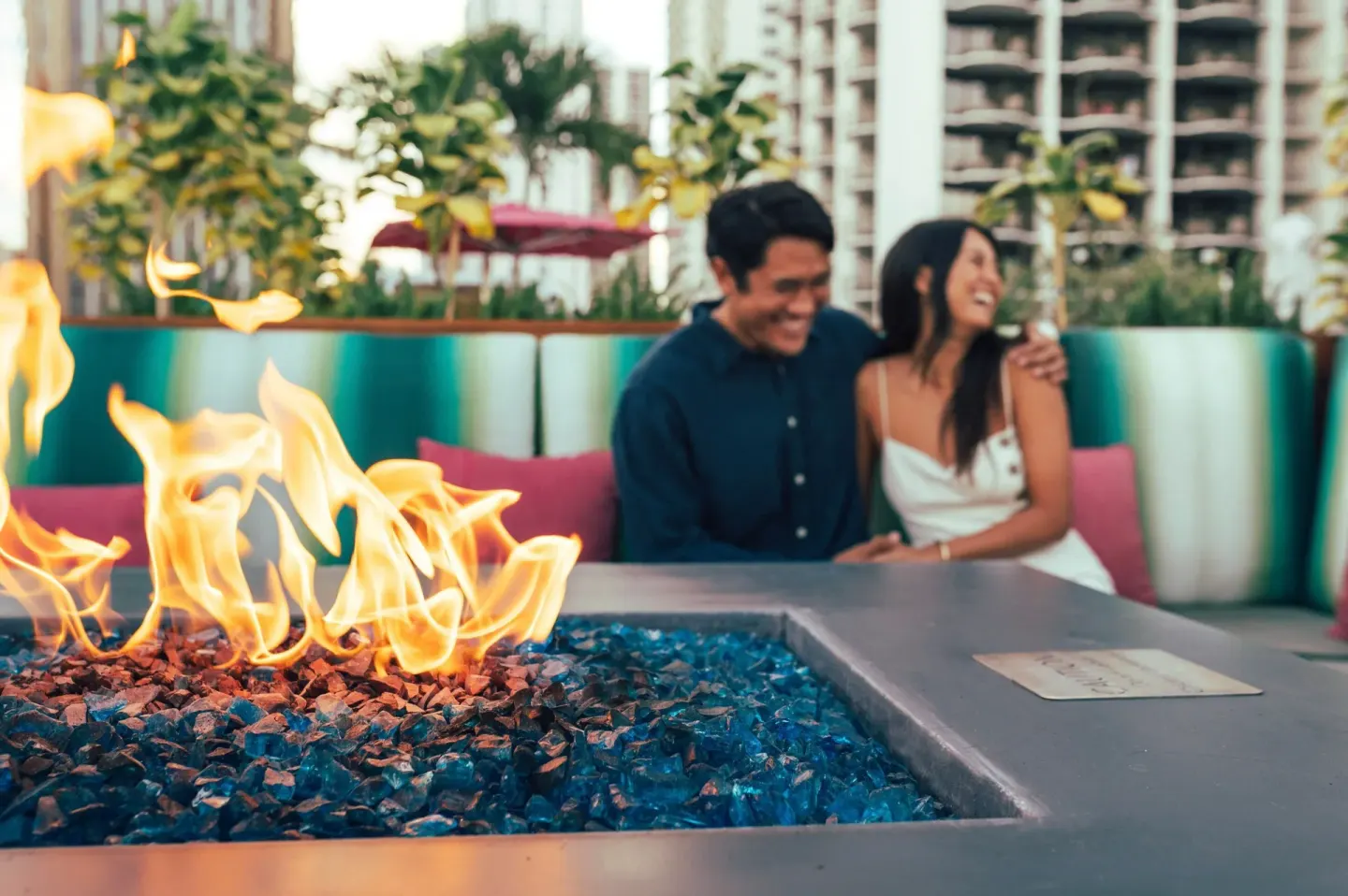 Guests sit by an outdoor fire table at Waikiki Beach Marriott Resort & Spa.