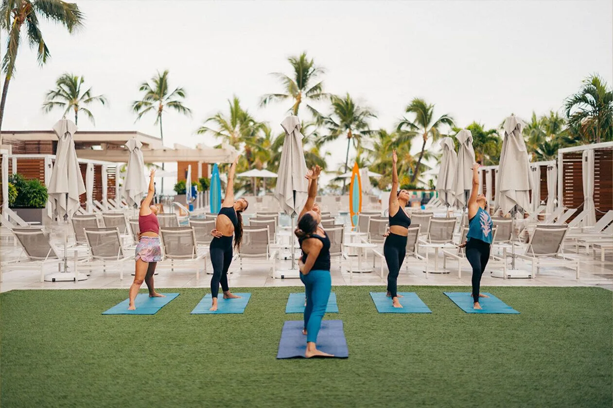 Outdoor yoga class on mats by the pool at Waikiki Beach Marriott Resort & Spa.