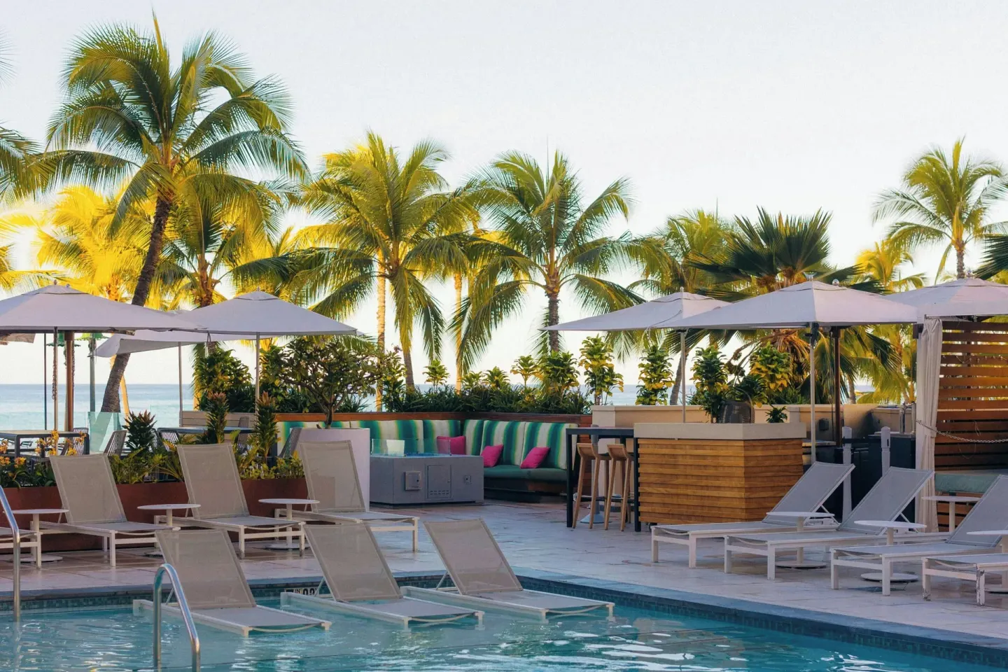 Poolside loungers, umbrellas and palms at Waikiki Beach Marriott Resort & Spa.