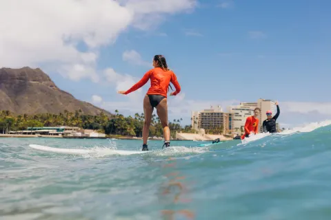Surfers ride small waves near Diamond Head by Waikiki Beach Marriott Resort & Spa.