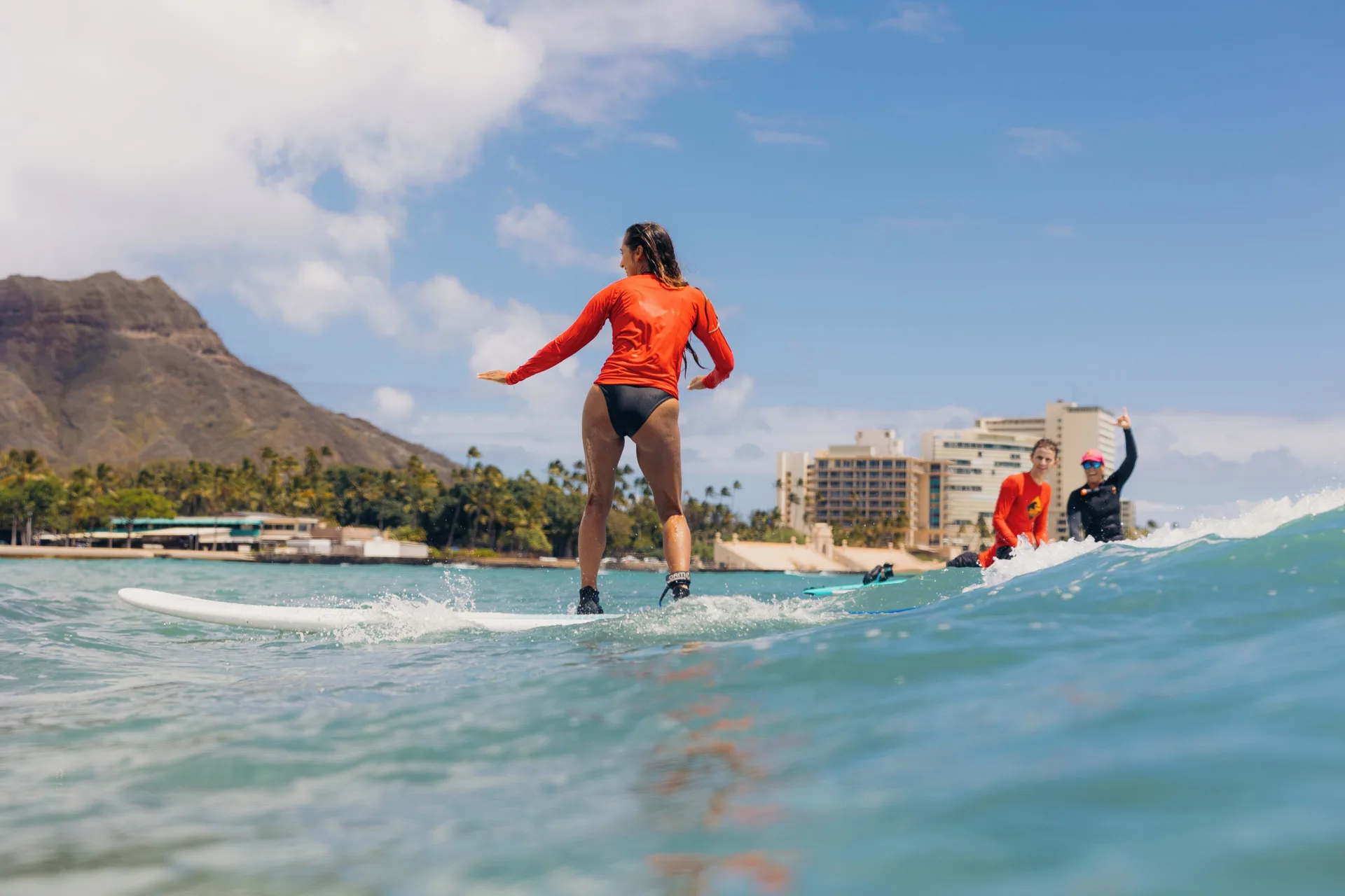 Surfers ride small waves near Diamond Head by Waikiki Beach Marriott Resort & Spa.