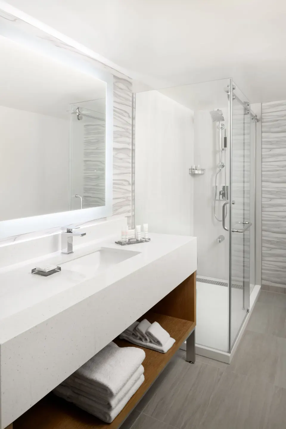 Junior Suite bathroom vanity and glass shower at Waikiki Beach Marriott Resort & Spa.