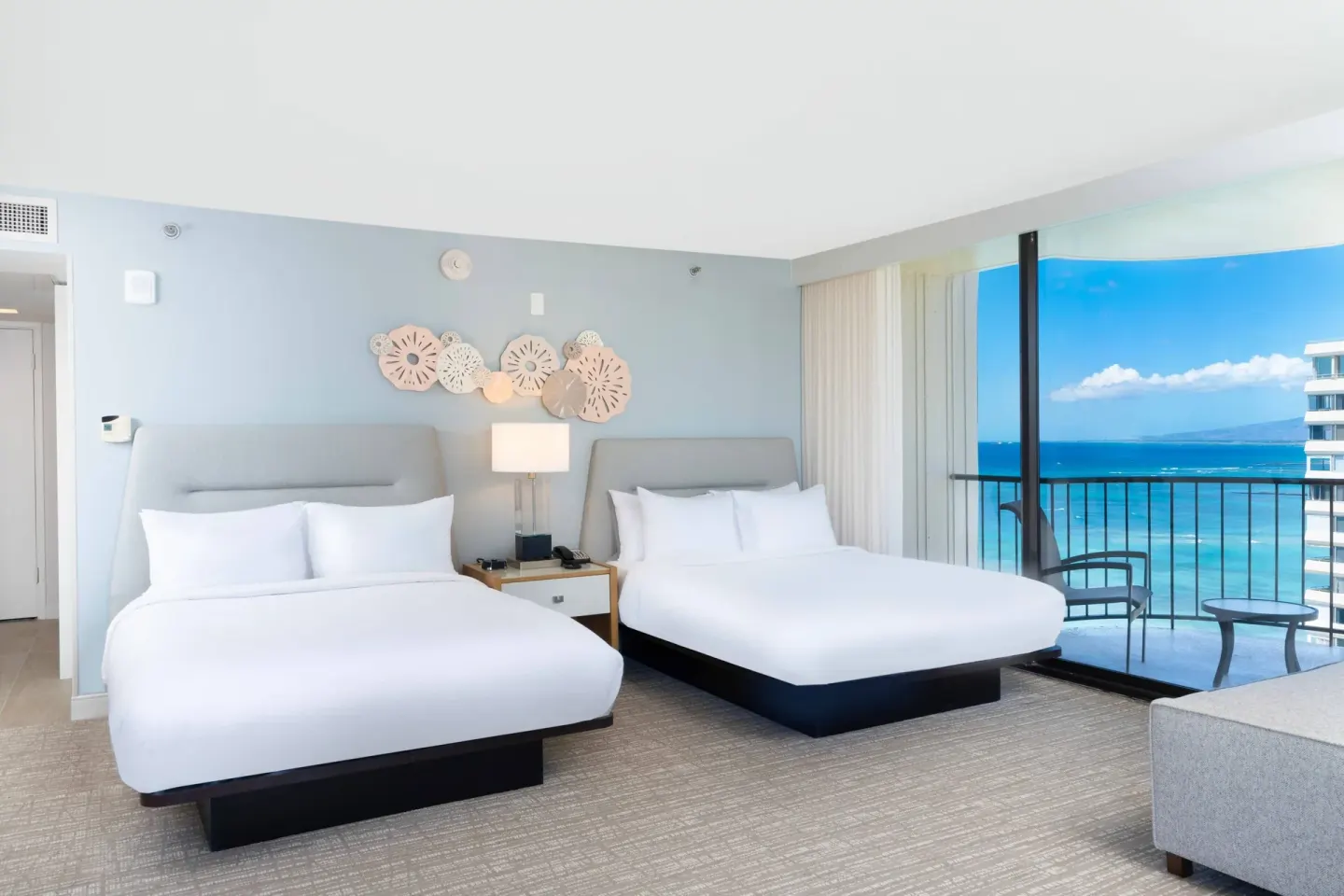 Two beds in a junior suite with ocean-view balcony at Waikiki Beach Marriott Resort & Spa.