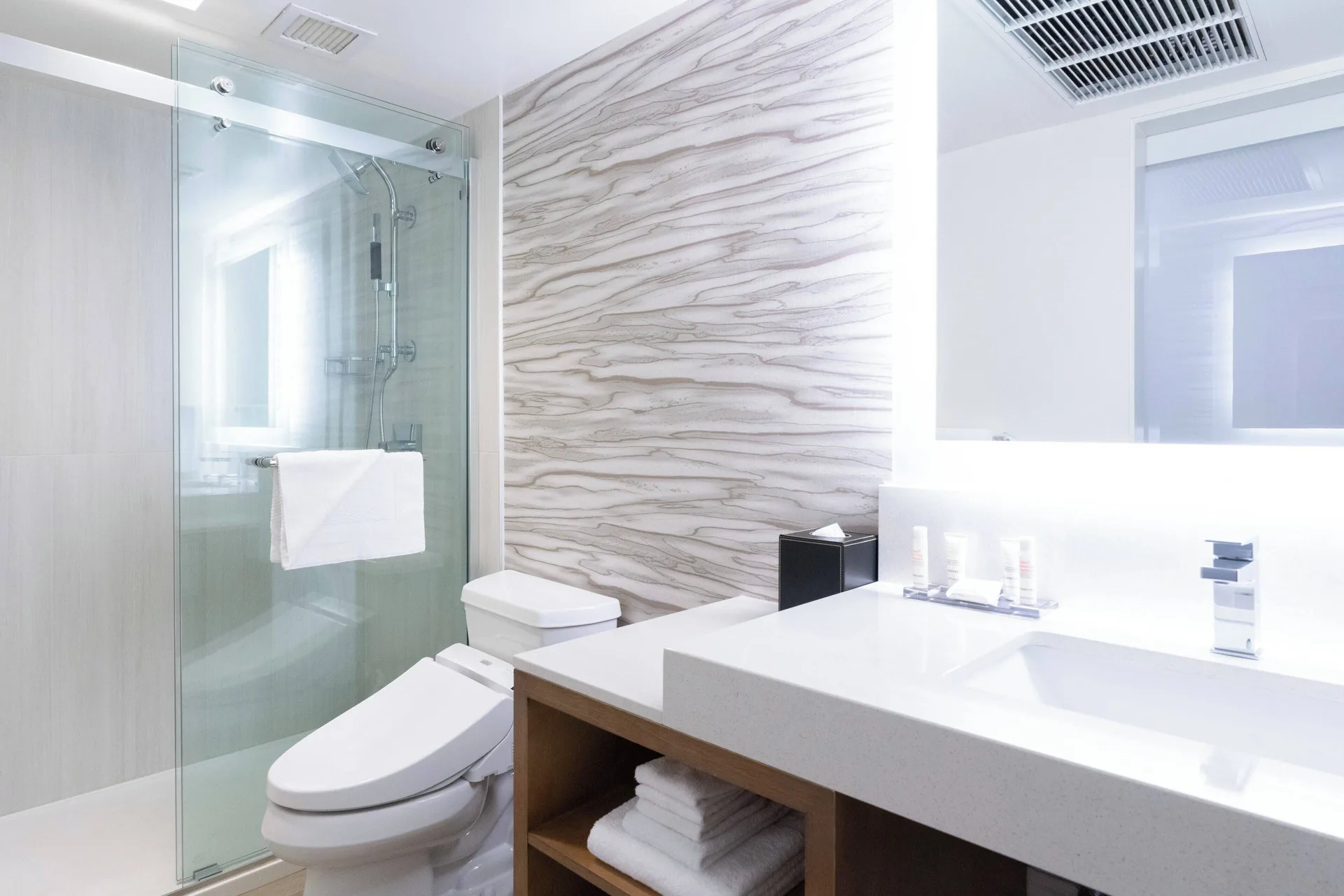 Bright bathroom with glass shower and vanity at Waikiki Beach Marriott Resort & Spa.