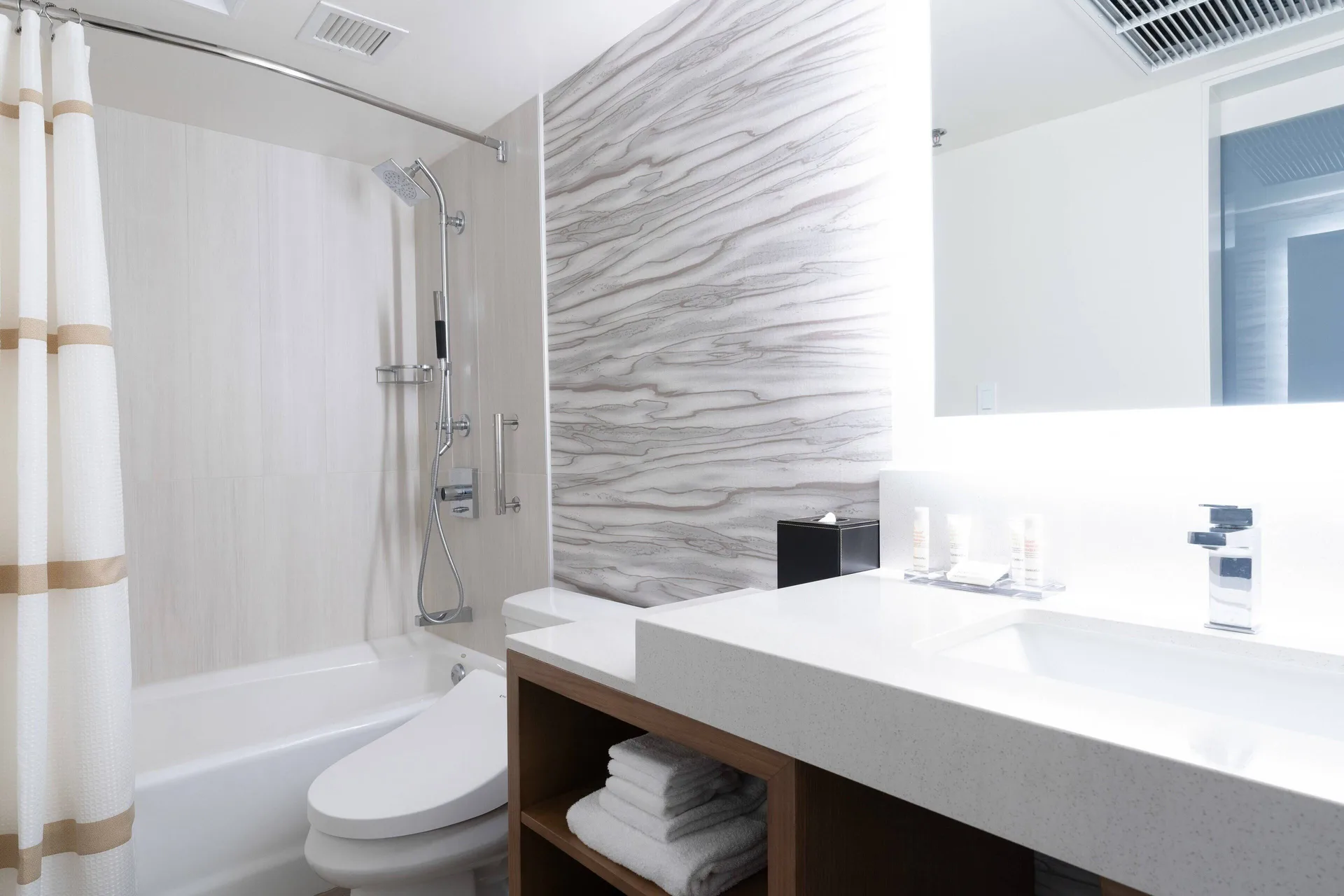 Bathroom with tub shower and white vanity at Waikiki Beach Marriott Resort & Spa.