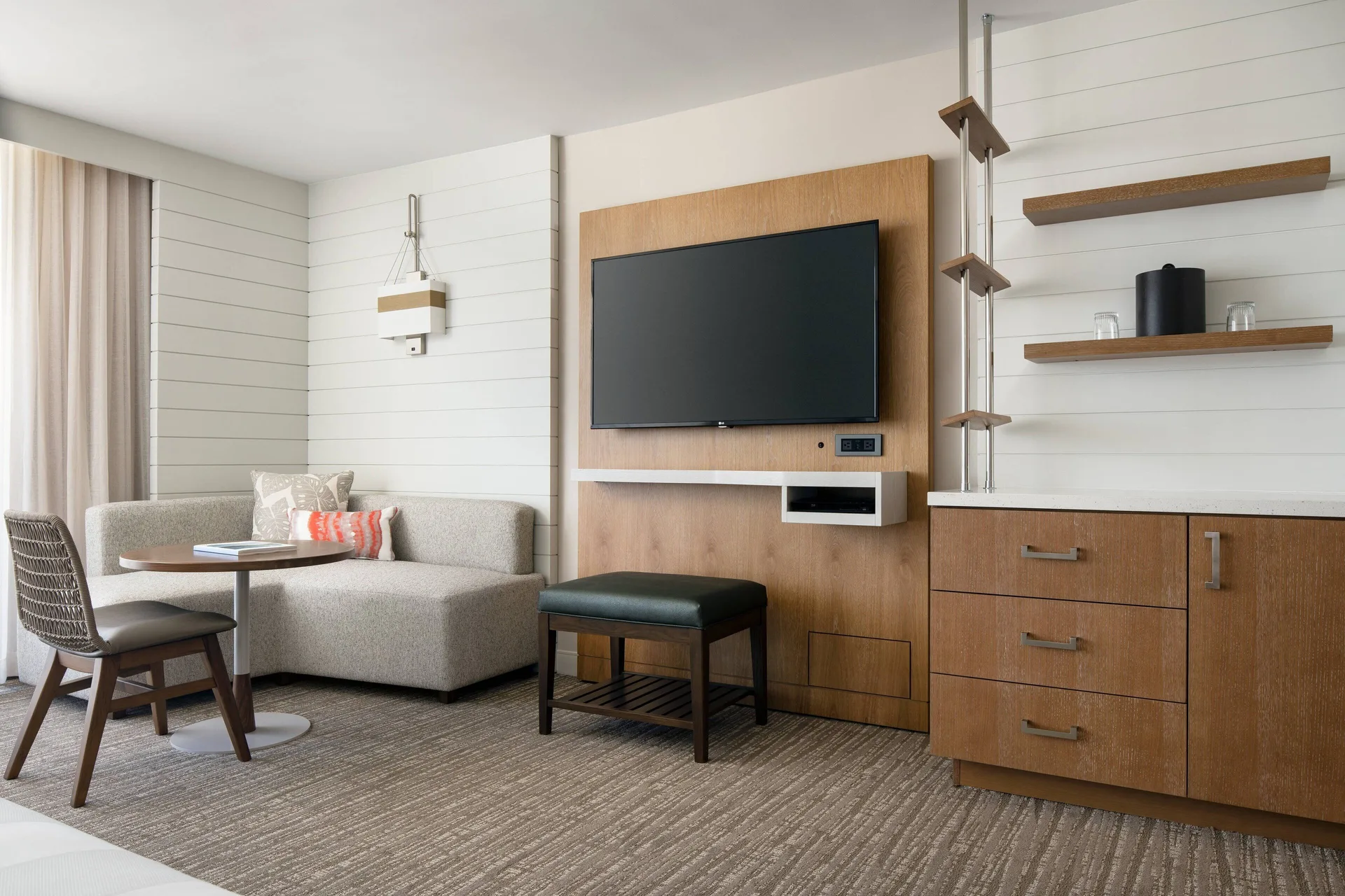 Guest room seating, TV, and storage wall at Waikiki Beach Marriott Resort & Spa.