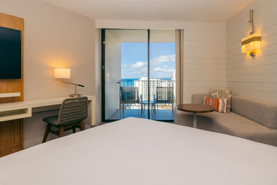 King bed, sofa bed, desk, and balcony view at Waikiki Beach Marriott Resort & Spa.