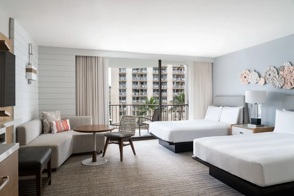 Two-bed Waikiki Beach Marriott Resort & Spa balcony room at Waikiki Beach Marriott Resort & Spa with sofa and balcony doors.