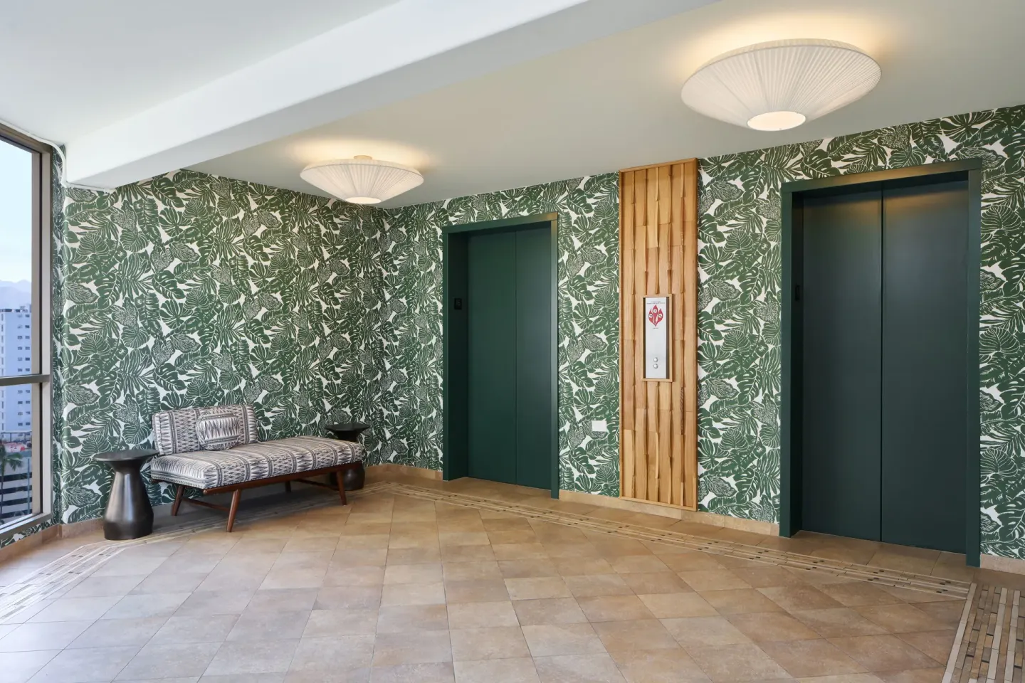 Elevator landing with green leaf wallpaper and a bench at Waikiki Malia.