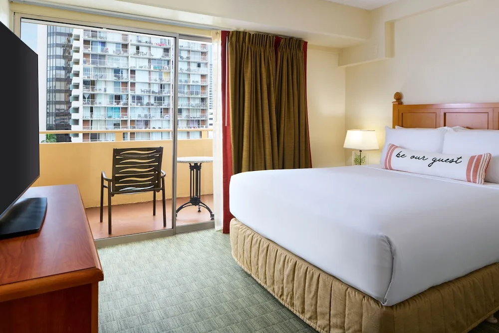 King bed guest room with balcony and city view at Waikiki Malia.
