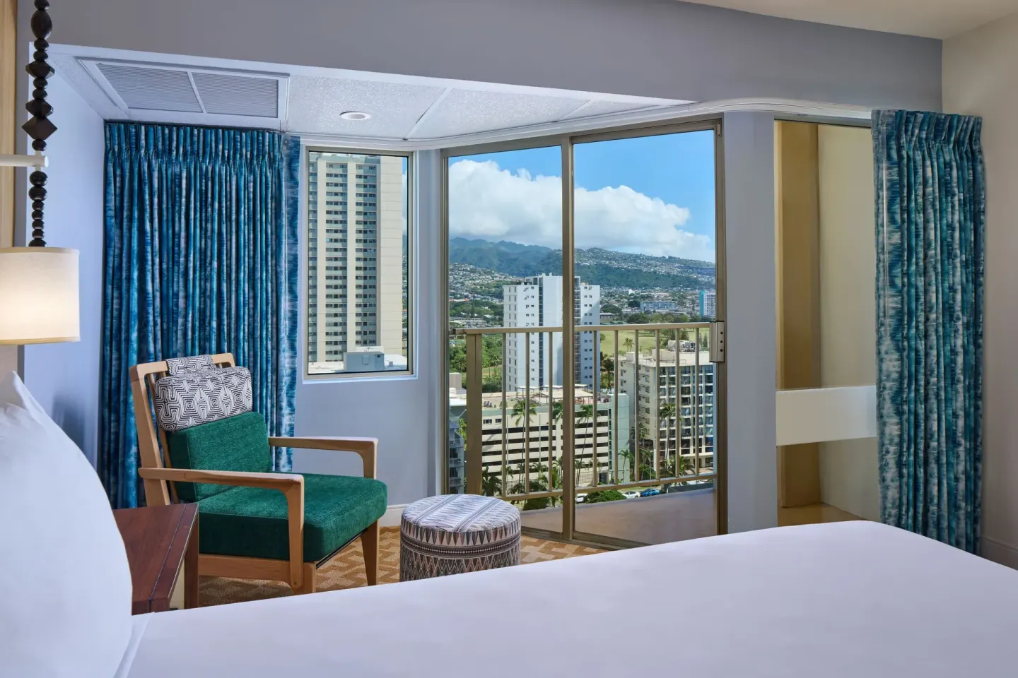 City View guest room seating area, bed, and balcony view at Waikiki Malia.