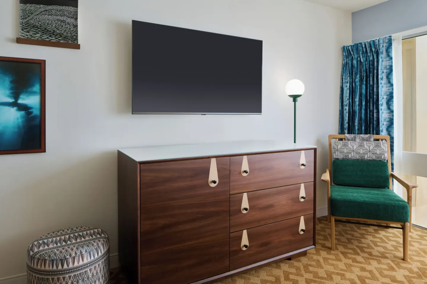 City View room TV wall with dresser, chair, lamp, and blue curtains at Waikiki Malia.